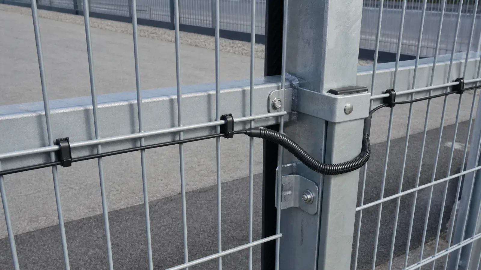 Protected fiber PIDS cable crossing a welded-mesh fence post